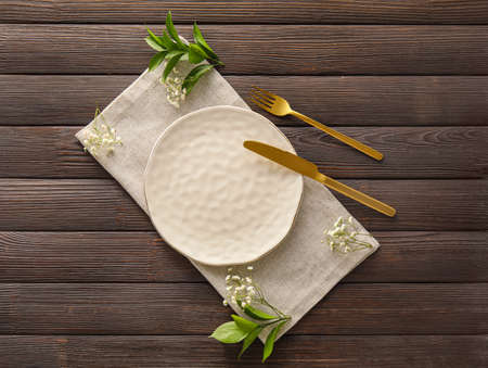 Stylish table setting and floral decor on dark wooden background