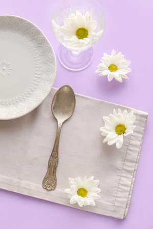 Simple table setting with white chamomile flowers on color backgroundの写真素材