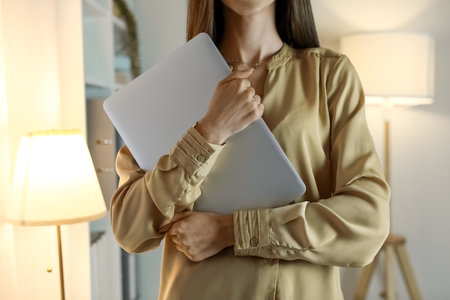 Beautiful businesswoman with laptop late in the eveningの写真素材