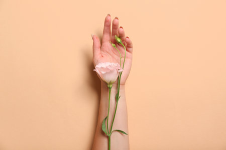 Woman with beautiful roses on beige backgroundの写真素材