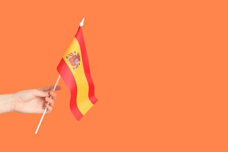 Woman with flag of Spain on orange backgroundの写真素材