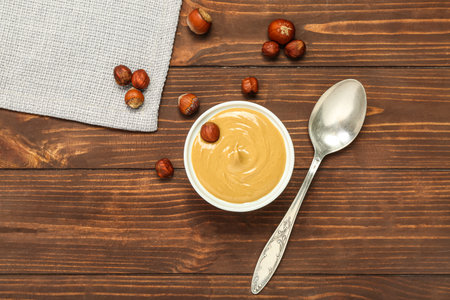 Bowl of tasty hazelnut butter on wooden backgroundの写真素材