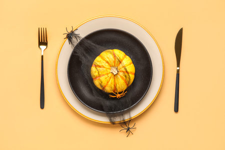 Halloween table setting with pumpkin and spiders on color backgroundの写真素材