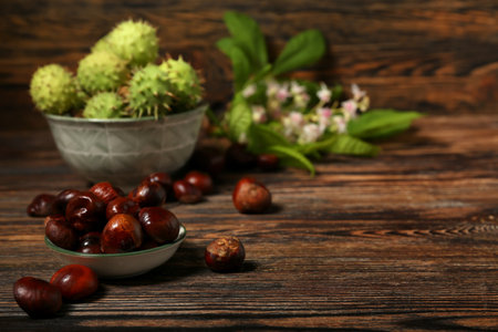 Bowl of fresh chestnuts on wooden background