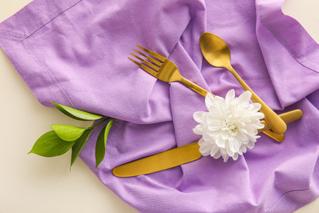 Cutlery, napkin and chrysanthemum flowers on light backgroundの写真素材