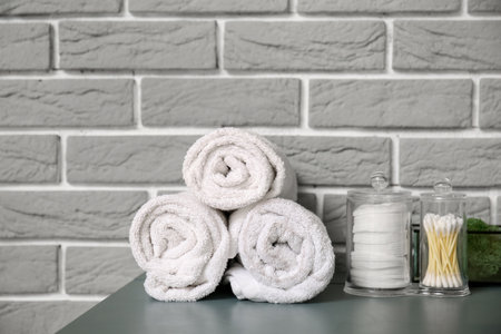 Bath accessories on table near gray brick wallの写真素材
