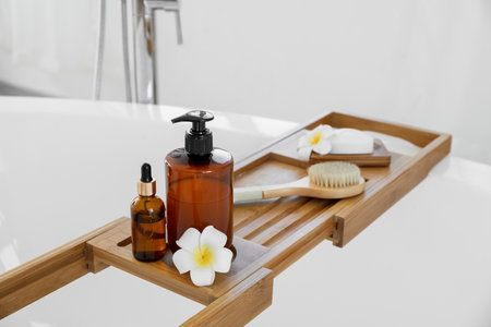 Bathtub tray with bath accessories and plumeria flowers, closeupの写真素材