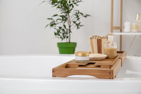 Wooden board with accessories on bathtubの写真素材