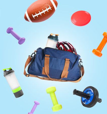 Flying sports bag and different equipment on light blue backgroundの写真素材