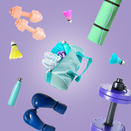 Flying sports bag and different equipment on lilac backgroundの写真素材