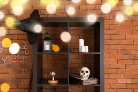 Shelving unit with Halloween decor near brick wall in roomの写真素材