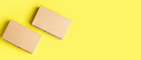 Blank cardboard boxes on yellow background with space for text, top viewの写真素材
