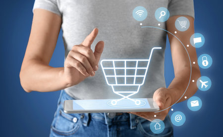 Woman with tablet computer on blue background, closeup. online shopping conceptの写真素材
