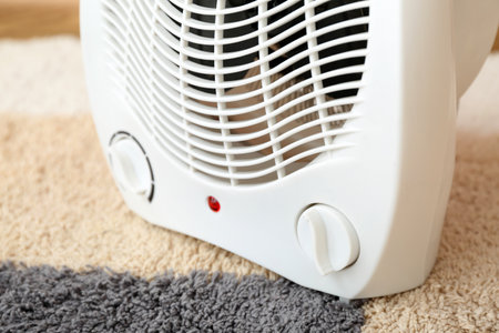 Electric fan heater on carpet, closeupの写真素材