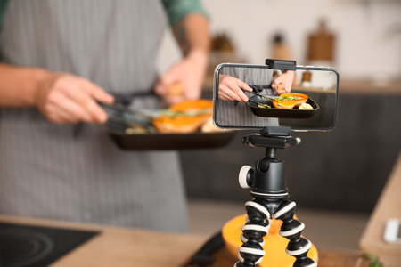 Male chef recording new video recipe in kitchenの写真素材