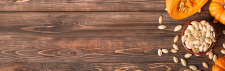 Bowl of natural pumpkin seeds on wooden background with space for text, top viewの写真素材