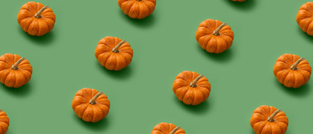 Many ripe pumpkins on green background. pattern for designの写真素材