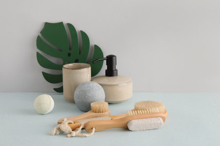 Bath accessories with massage brushes on light background