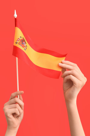 Woman with flag of Spain on red backgroundの写真素材