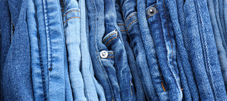 Different stylish jeans clothes as background, closeupの写真素材