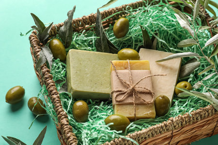 Basket with soap bars and green olives on color background, closeupの写真素材