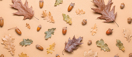 Scattered acorns and autumn leaves on beige background, top view