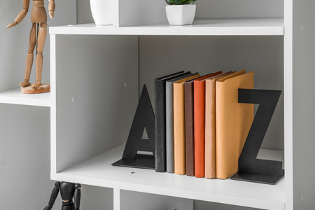 Bookcase with stylish holder near light wallの写真素材