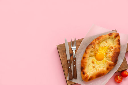 Wooden board with tasty Ajarian khachapuri on pink backgroundの写真素材