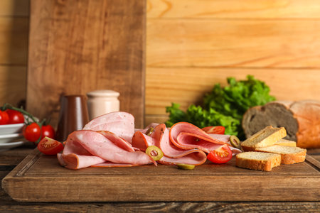 Board with tasty ham and crackers on wooden tableの写真素材