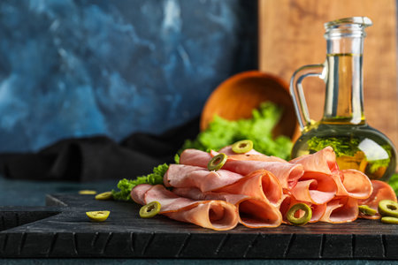 Board with rolled slices of ham on table, closeupの写真素材