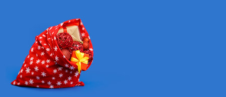 Santa Claus bag full of gifts and decorations on blue background with space for textの写真素材