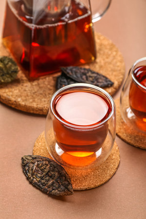 Glass of puer tea on brown background, closeupの写真素材