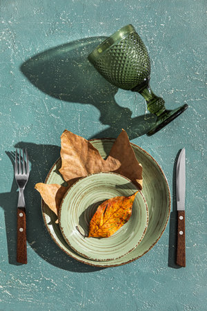 Autumn table setting with fallen leaves on grunge background