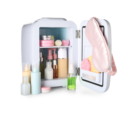 Small refrigerator with cosmetic products and sleeping mask on white backgroundの写真素材