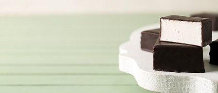 Tasty bird's milk candies on wooden table, closeup. Banner designの写真素材