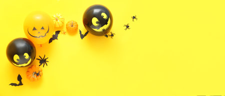 Composition with Halloween decor and balloons on yellow background with space for text, top viewの写真素材