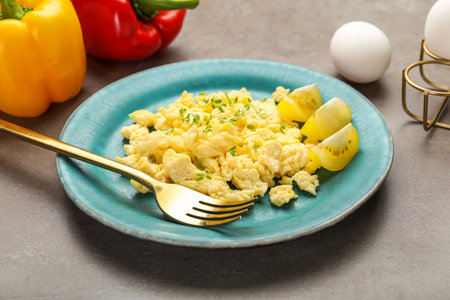 Plate of tasty scrambled eggs on grunge background
