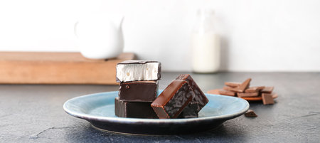 Plate with tasty bird's milk candies on tableの写真素材