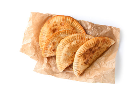Baking paper with tasty chebureks on white backgroundの写真素材