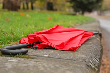 Stylish bright umbrella on parapet outdoors