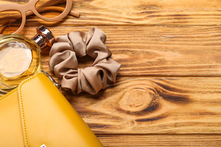 Perfume bottle, sunglasses, bag and silk scrunchy on wooden background, closeupの写真素材
