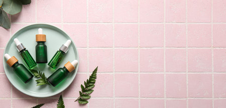 Bottles of cosmetic serum and plant leaves on light color background with space for text, top viewの写真素材