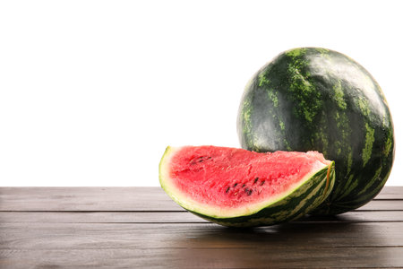 Slice of ripe watermelon on wooden table against white backgroundの写真素材