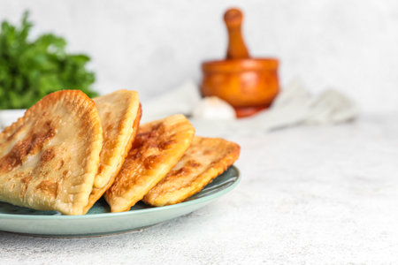 Plate with tasty chebureks on light tableの写真素材