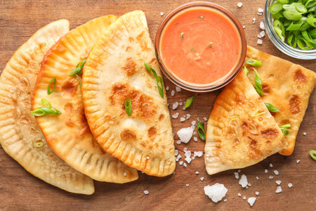 Wooden board with tasty chebureks and sauce, closeupの写真素材