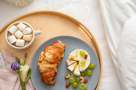Wooden tray with delicious breakfast on bed, closeupの写真素材