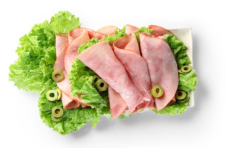 Plate with rolled slices of ham and lettuce on white backgroundの写真素材