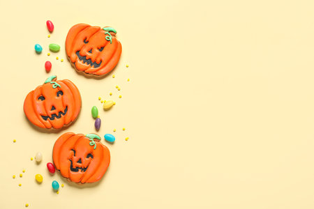 Tasty Halloween pumpkin cookies with jellies on beige backgroundの写真素材