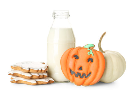 Halloween cookies with pumpkin and bottle of milk on white backgroundの写真素材