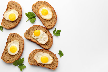 Tasty sandwiches with fried quail eggs on white background